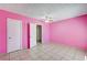 Spacious pink bedroom with tile flooring, ceiling fan, and two white doors at 5121 Gains Mill St, Las Vegas, NV 89122