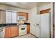 Efficient kitchen features wood cabinets, white appliances, and tile flooring for easy maintenance at 5121 Gains Mill St, Las Vegas, NV 89122
