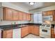 Well-lit kitchen features wood cabinets, tile flooring, and essential appliances for everyday cooking at 5121 Gains Mill St, Las Vegas, NV 89122