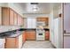 Practical kitchen featuring wood cabinets, double sink, and essential appliances for convenient cooking at 5121 Gains Mill St, Las Vegas, NV 89122