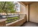 A quaint balcony with a view of the parking area and a mature tree at 5415 W Harmon Ave # 1162, Las Vegas, NV 89103