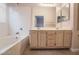 Bathroom features a double sink vanity with light wood cabinets and tiled shower-tub at 5415 W Harmon Ave # 1162, Las Vegas, NV 89103