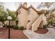 Exterior view of a two-story condo featuring private entrance and mature landscaping at 5415 W Harmon Ave # 1162, Las Vegas, NV 89103