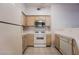 Kitchen with white appliances and light wood cabinetry at 5415 W Harmon Ave # 1162, Las Vegas, NV 89103