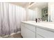 Bathroom showcasing sleek vanity with modern fixtures, shower with a patterned curtain, and neutral color palette at 5424 Geneive Ln # 105, Las Vegas, NV 89108
