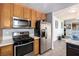 Updated kitchen with stainless steel appliances, wooden cabinets, granite countertops, and hardwood flooring at 5424 Geneive Ln # 105, Las Vegas, NV 89108