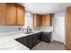 Well-lit kitchen with wooden cabinets, granite countertops, modern appliances, and a sleek, functional design at 5424 Geneive Ln # 105, Las Vegas, NV 89108