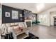 Contemporary living room with a black accent wall, cozy fireplace, and laminate flooring at 5424 Geneive Ln # 105, Las Vegas, NV 89108