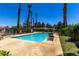 Community pool featuring clear blue water, lush landscaping, and tall palm trees at 5424 Geneive Ln # 105, Las Vegas, NV 89108