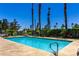 Community pool featuring clear blue water, lounge chairs, and picnic tables at 5424 Geneive Ln # 105, Las Vegas, NV 89108