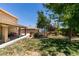 Expansive backyard showing the patio, fire pit, lush lawn, and various seating arrangements at 6109 Sandstone Mesa Dr, Las Vegas, NV 89130