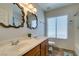 Bathroom features dual sinks, decorative mirrors, and tile floors at 6109 Sandstone Mesa Dr, Las Vegas, NV 89130