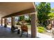 Covered patio area featuring comfortable seating with a view of the well-maintained backyard at 6109 Sandstone Mesa Dr, Las Vegas, NV 89130