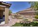 Lush backyard featuring a rock fountain, pavers, and artificial turf, creating a serene outdoor space at 6315 Carol Butte Ct, Las Vegas, NV 89141