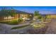 Beautifully landscaped backyard with a unique water feature, lush greenery, and inviting stone pathways at 6315 Carol Butte Ct, Las Vegas, NV 89141