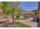Landscaped backyard oasis with a central water fountain, artificial grass, and mature trees at 6315 Carol Butte Ct, Las Vegas, NV 89141