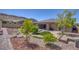 Expansive backyard with stone pathways, lush landscaping, and a charming water fountain at 6315 Carol Butte Ct, Las Vegas, NV 89141