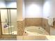 Bathroom features a bathtub, glass shower enclosure, and tile walls in a neutral color palette at 6441 Brushwood Ln, Las Vegas, NV 89107