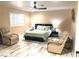 Spacious bedroom with light tile flooring, a ceiling fan, a window with shutters, and two tan leather chairs at 6441 Brushwood Ln, Las Vegas, NV 89107
