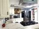 Well-lit kitchen features modern stainless steel appliances, white cabinets, and a quartz countertop with a gas cooktop at 6441 Brushwood Ln, Las Vegas, NV 89107