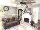 Comfortable living room with a white brick fireplace, ceiling fan, and wood-look flooring at 6441 Brushwood Ln, Las Vegas, NV 89107
