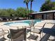 Community pool area with tables, lounge chairs, and lush landscaping, ideal for summer relaxation at 6441 Brushwood Ln, Las Vegas, NV 89107