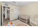 This beautiful Bedroom includes a white crib and a comfortable reading chair at 6964 Caldera St, Las Vegas, NV 89149