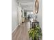 Hallway showcasing wood flooring, a decorative mirror, plants, and a view of the dining area at 6964 Caldera St, Las Vegas, NV 89149