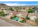 Backyard oasis with pool, spa, mature trees, and desert landscaping in a quiet neighborhood at 703 Jane Eyre Pl, Henderson, NV 89002