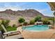 Inviting backyard with pool, spa, waterfall, mature trees and desert mountain views at 703 Jane Eyre Pl, Henderson, NV 89002