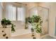 Bright bathroom featuring a soaking tub, glass-enclosed shower, and lush green plants for a spa-like feel at 703 Jane Eyre Pl, Henderson, NV 89002