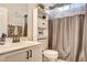 Bright bathroom featuring a large mirror, white vanity, and toilet with coordinated decorative items at 703 Jane Eyre Pl, Henderson, NV 89002