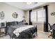 Stylish bedroom with dark furniture, a large window, and black and white accents at 703 Jane Eyre Pl, Henderson, NV 89002