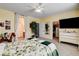 Spacious bedroom showcasing a floral bedspread, large TV, and convenient access to the bathroom and closet at 703 Jane Eyre Pl, Henderson, NV 89002