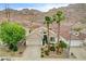 Exterior elevation of a single-story home with desert landscaping and mature palm trees at 703 Jane Eyre Pl, Henderson, NV 89002
