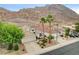 View of the home's exterior with palm trees and mountain views in the distance at 703 Jane Eyre Pl, Henderson, NV 89002
