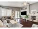 Inviting living room with hardwood floors, fireplace, and French doors leading to the pool area at 703 Jane Eyre Pl, Henderson, NV 89002