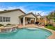 Beautiful backyard pool and spa is surrounded by a patio and luscious landscape at 703 Jane Eyre Pl, Henderson, NV 89002