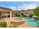 The beautiful pool features a spa and rock waterfall with an outdoor kitchen on the patio at 703 Jane Eyre Pl, Henderson, NV 89002