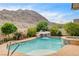 Gorgeous pool with rock waterfall and spa, set against a mountain backdrop at 703 Jane Eyre Pl, Henderson, NV 89002