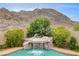 Beautiful waterfall feature cascades into the refreshing pool with mountain views in the background at 703 Jane Eyre Pl, Henderson, NV 89002