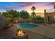 Inviting backyard featuring a pool, a fire pit, and ambient string lights for serene outdoor enjoyment at 741 Wildwood Beach Ave, Henderson, NV 89052