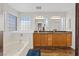 Primary bathroom with double sinks, soaking tub, and glass block window at 741 Wildwood Beach Ave, Henderson, NV 89052