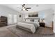 Bright bedroom featuring a large bed, ceiling fan, and natural light through windows and glass paneled doors at 741 Wildwood Beach Ave, Henderson, NV 89052