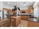 Bright kitchen features stainless appliances, wood floors, granite counters, and an island with hanging pot rack at 741 Wildwood Beach Ave, Henderson, NV 89052