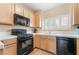 Functional kitchen features black appliances, light wood cabinets, and tile floors at 7450 S Eastern Ave # 1058, Las Vegas, NV 89123
