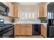 Efficient kitchen with black appliances, light wood cabinets, and a window over the sink at 7450 S Eastern Ave # 1058, Las Vegas, NV 89123