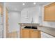 View of the kitchen from the living room featuring wood cabinets and granite counters at 75 E Agate Ave # 206, Las Vegas, NV 89123