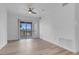 Open living room with ceiling fan, hardwood floors, and sliding glass door to the balcony at 75 E Agate Ave # 206, Las Vegas, NV 89123