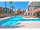 Relaxing pool area featuring lounge chairs, umbrellas, palm trees and a gorgeous building at 75 E Agate Ave # 206, Las Vegas, NV 89123